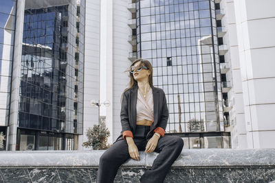 Young woman sitting outside building