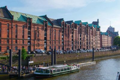 Boats in river against buildings in city