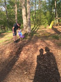 Shadow of children standing in forest