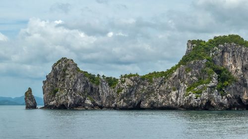 Rock formations by sea against sky