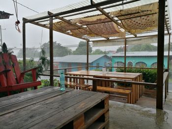 Chairs and table by sea against sky
