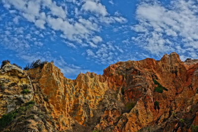 Low angle view of rocky mountains against sky