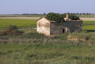 Abandoned built structure on field against clear sky