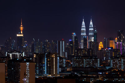 Illuminated cityscape against sky at night