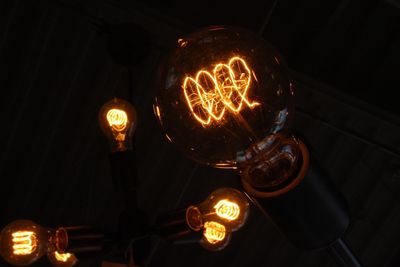 Low angle view of illuminated light bulbs