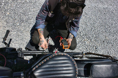 High angle view of man examining motorcycle