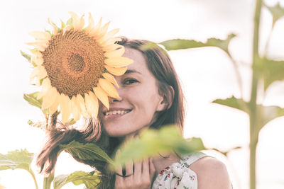 Portrait of a smiling young woman with sunflower