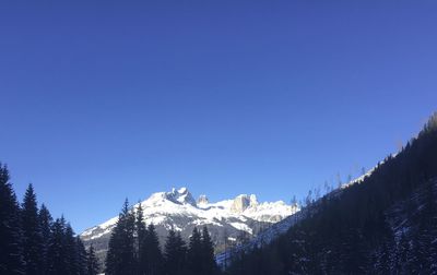 Scenic view of snowcapped mountains against clear blue sky