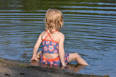 Girl sitting at lakeshore