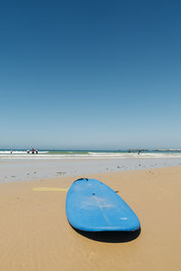 Scenic view of beach against clear blue sky