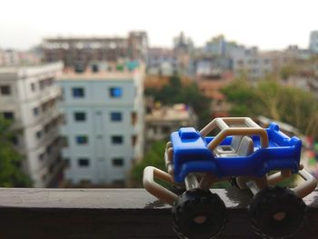 Close-up of toy car against buildings in city