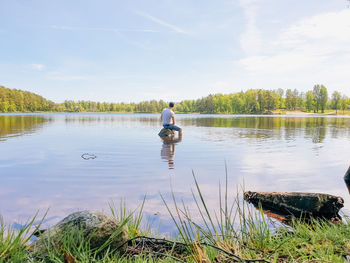 Rear view of man in lake against sky