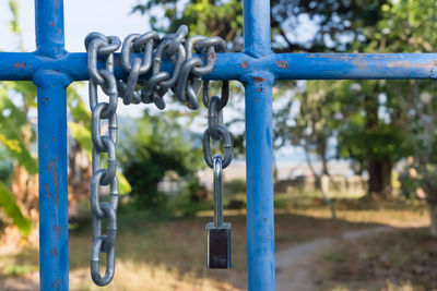 Close-up of chain hanging on metal fence