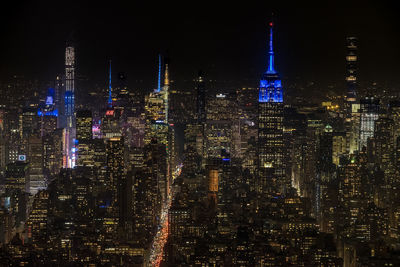 Illuminated cityscape against sky at night