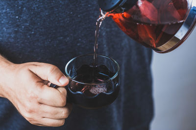 Close-up of hand pouring drink in glass