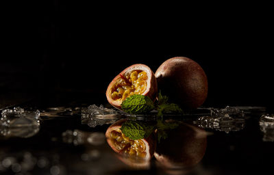 Close-up of fruits on table against black background