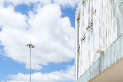 Low angle view of white building against cloudy sky