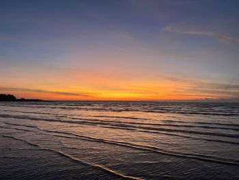 Scenic view of beach against sky during sunset