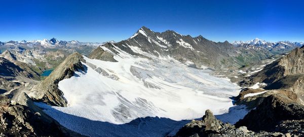 Scenic view of snowcapped mountains against clear blue sky