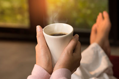 Close-up of hand holding coffee cup