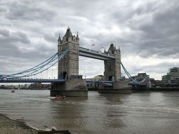 View of bridge over river against cloudy sky