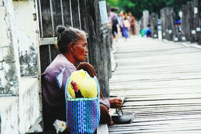 Side view of mature woman begging on pier