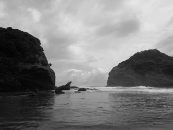 Rock formation in sea against sky