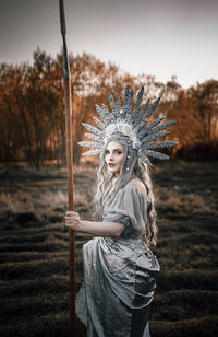 Portrait of woman standing against trees