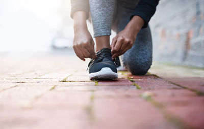 Low section of man tying shoelace