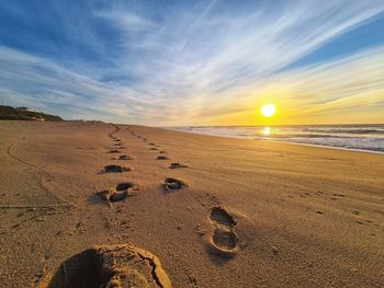 Scenic view of beach against sky during sunset