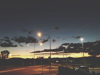 Illuminated road against sky at night