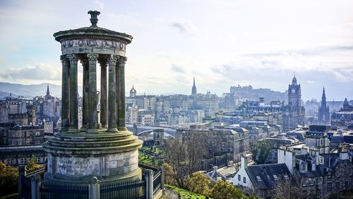 View of cityscape against cloudy sky