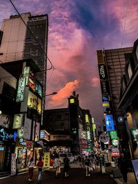 City street and buildings against sky during sunset