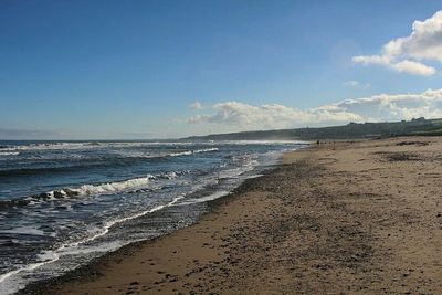 Scenic view of beach against blue sky