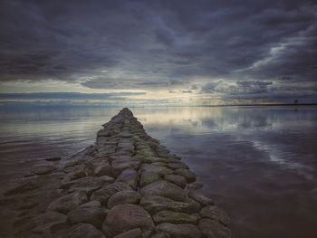 Rocks on sea against sky during sunset