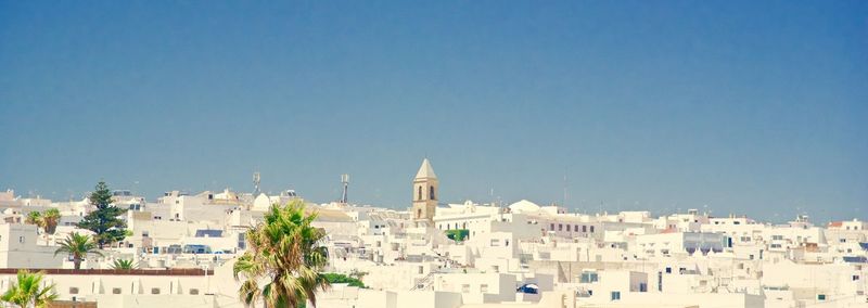 View of cityscape against clear blue sky