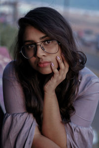 Close-up portrait of beautiful young woman sitting outdoors