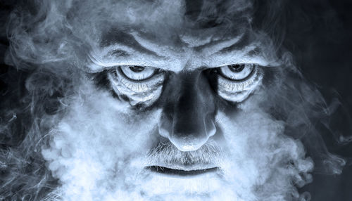 Close-up portrait of spooky man amidst smoke