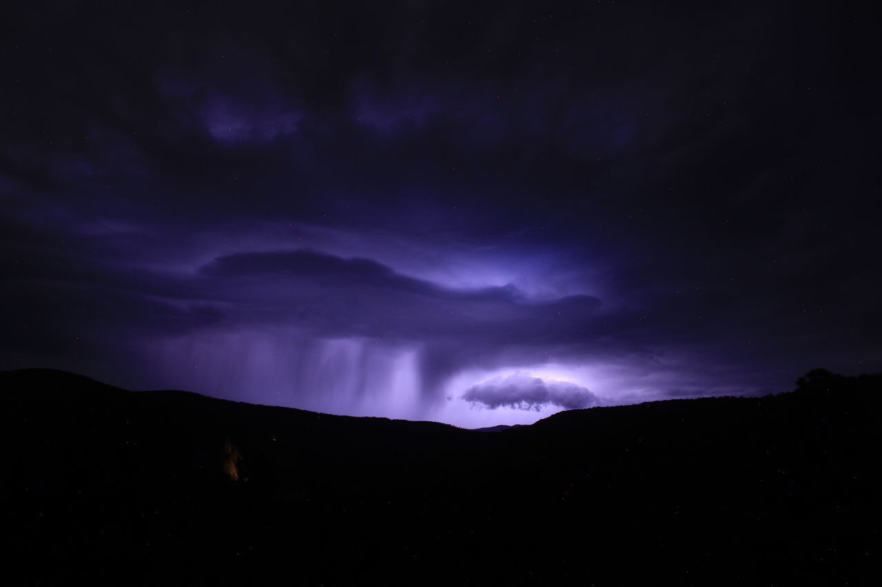 sky, night, beauty in nature, darkness, cloud, mountain, scenics - nature, environment, storm, dramatic sky, lightning, power in nature, thunderstorm, nature, no people, dark, landscape, silhouette, star, awe, mountain range, storm cloud, thunder, outdoors, purple, astronomy