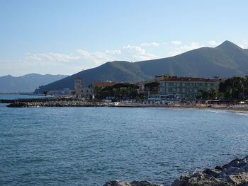 Scenic view of sea by buildings against sky