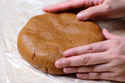 Cropped hands of woman preparing cookie at table