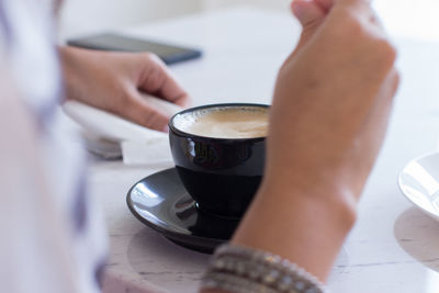 Midsection of man holding coffee cup