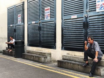 Full length of man using mobile phone on street