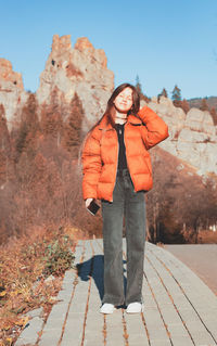 Portrait of a girl in a jacket on a mountain background.