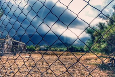 Close-up of chainlink fence against sky