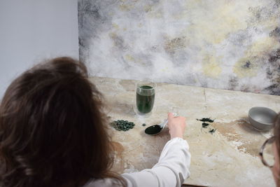 High angle view of woman drinking water at home