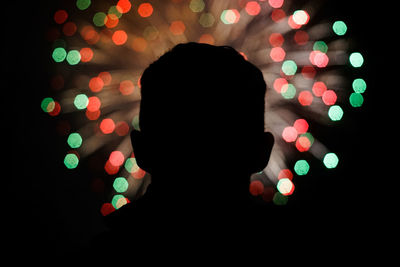 Close-up of man in front of illuminated fireworks