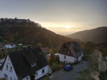 High angle view of houses and buildings against sky at sunset