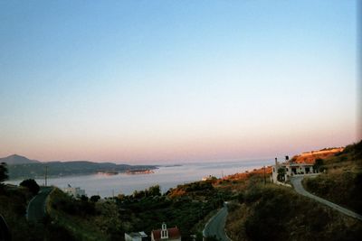 High angle view of sea and cityscape against clear sky