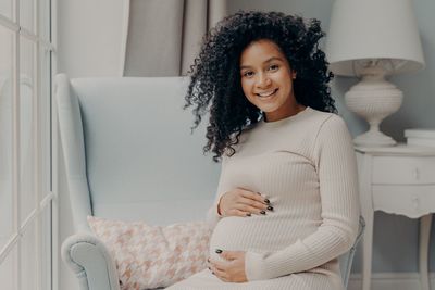 Portrait of smiling woman standing at home